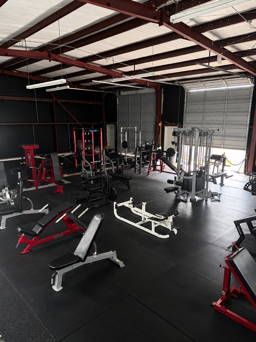 Roll-up garage doors open with benches, racks, and cable stack